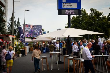 Publiek geniet van wielerrace met livestream op de achtergrond