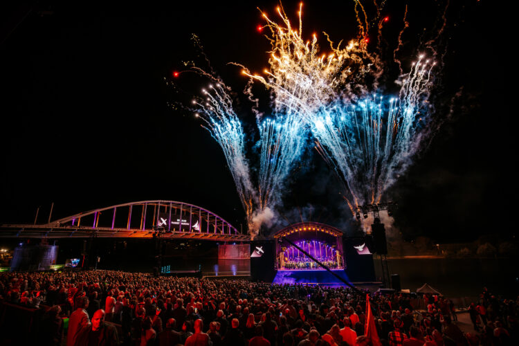 Outdoor LED screen hanging, with IMAG screens positioned on either side of the stage.