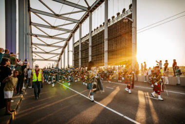 Parade on John Frost Bridge with LED screen hanging from the bridge.